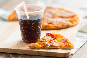 Image showing close up of pizza with coca cola on table