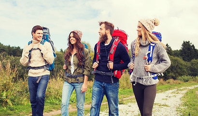 Image showing group of smiling friends with backpacks hiking