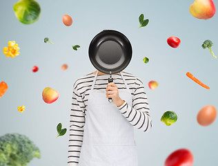 Image showing man or cook in apron hiding face behind frying pan