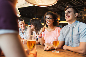 Image showing happy friends drinking beer and talking at bar