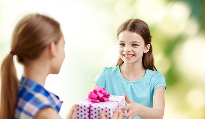 Image showing happy girls with birthday present over green