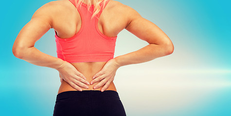 Image showing close up of sporty woman touching her back