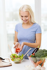 Image showing smiling woman cooking vegetable salad at home