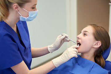 Image showing female dentist checking patient girl teeth