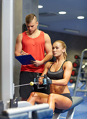 Image showing man and woman flexing muscles on gym machine