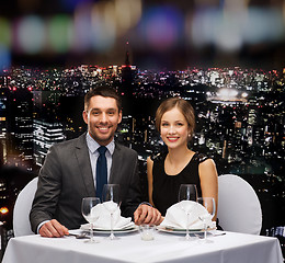 Image showing smiling couple holding hands at restaurant