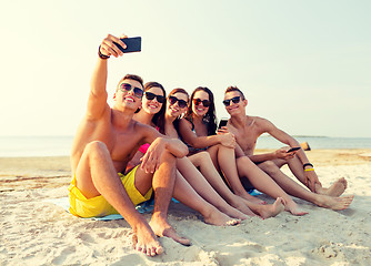 Image showing friends with smartphones on beach