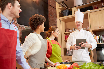 Image showing happy friends with tablet pc in kitchen