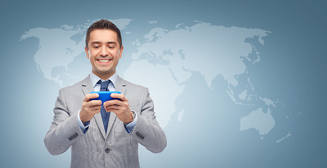 Image showing happy businessman texting message on smartphone