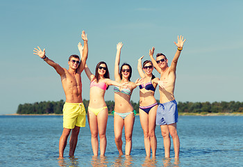 Image showing smiling friends in sunglasses on summer beach