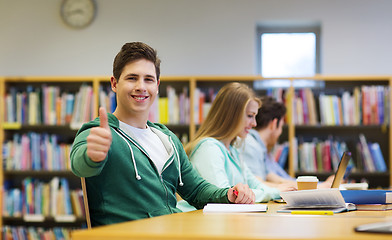 Image showing happy student boy preparing to exam in library