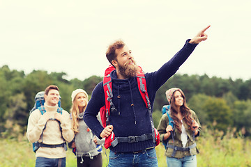 Image showing smiling hikers with backpacks pointing finger