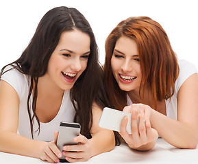 Image showing two smiling teenagers with smartphones