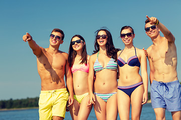 Image showing smiling friends in sunglasses on summer beach