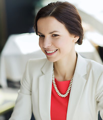 Image showing happy woman sitting at table in restaurant