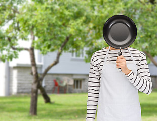 Image showing man or cook in apron hiding face behind frying pan