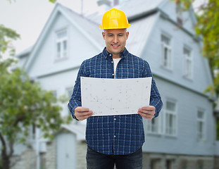 Image showing smiling builder with blueprint over house