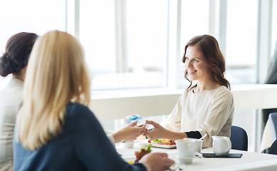 Image showing happy women giving birthday present at restaurant