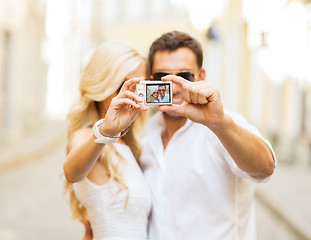 Image showing travelling couple taking photo picture with camera