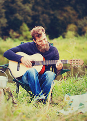 Image showing smiling man with guitar and dixie in camping