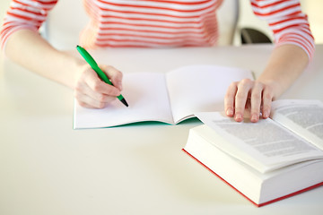 Image showing close up of female hands with book and notebook