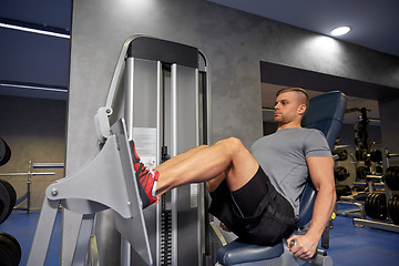 Image showing man flexing leg muscles on gym machine
