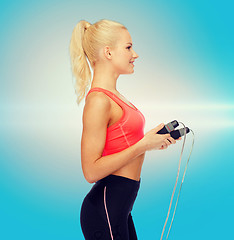 Image showing smiling sporty woman with skipping rope