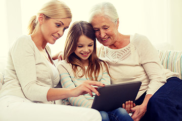 Image showing smiling family with tablet pc at home