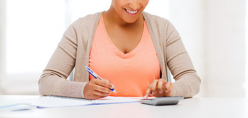 Image showing businesswoman working with calculator in office