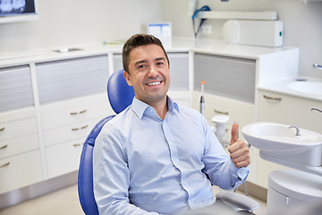 Image showing happy man showing thumbs up at dental clinic