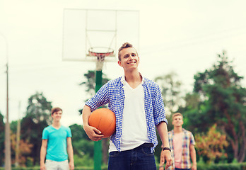 Image showing group of smiling teenagers playing basketball