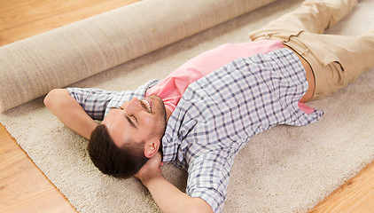 Image showing happy man lying carpet or rug at home