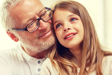 Image showing grandfather with crying granddaughter at home