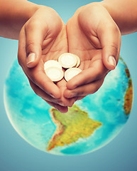 Image showing cupped hands holding euro coins over earth globe