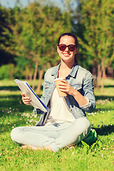 Image showing smiling young girl with notebook and coffee cup