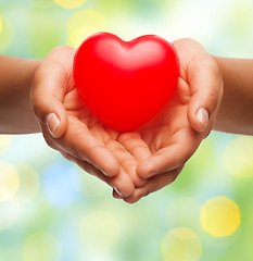 Image showing close up of female hands holding small red heart