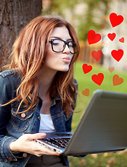 Image showing happy student girl writing to notebook at campus