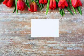 Image showing close up of red tulips and blank paper or letter