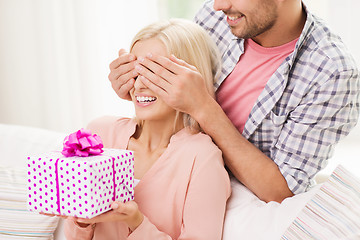 Image showing happy man giving woman gift box at home