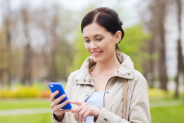Image showing smiling woman calling on smartphone in park