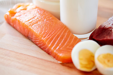 Image showing close up of salmon fillets, eggs and milk on table