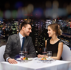 Image showing smiling couple eating main course at restaurant