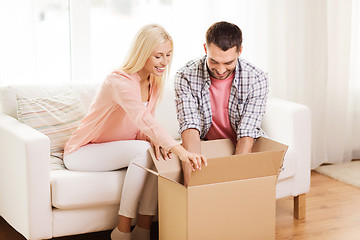 Image showing happy couple with cardboard box or parcel at home