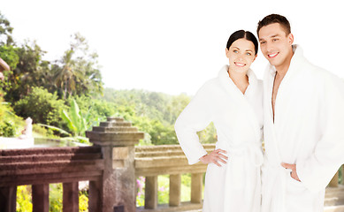 Image showing happy couple in bathrobes over spa hotel resort