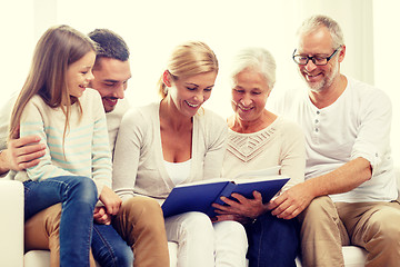 Image showing happy family with book or photo album at home