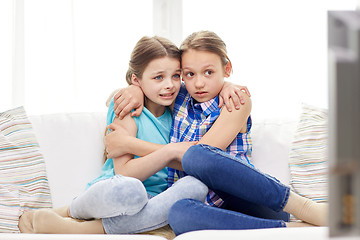 Image showing scared little girls watching horror on tv at home