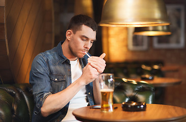 Image showing man drinking beer and smoking cigarette at bar