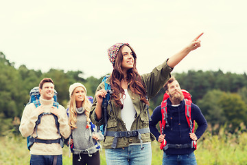 Image showing smiling hikers with backpacks pointing finger