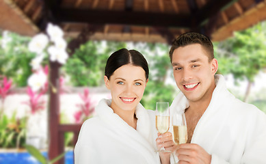 Image showing happy couple in bathrobes with champagne at resort