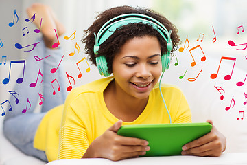 Image showing happy african woman with tablet pc and headphones